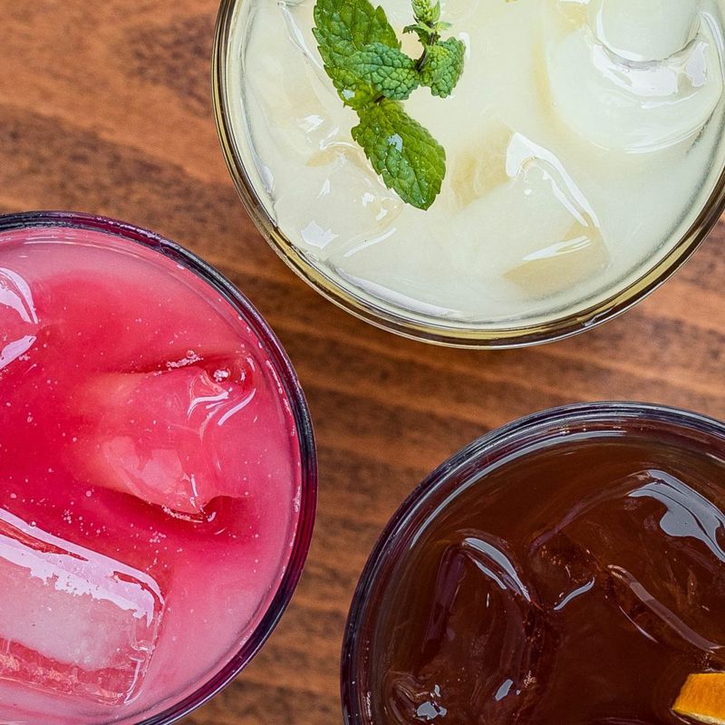 Trois boissons fraîches maison vues de près : citronnade à la menthe, berry lemonade et thé glacé