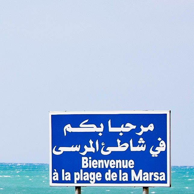 Panneau « Bienvenue à la plage de la Marsa » face à la mer