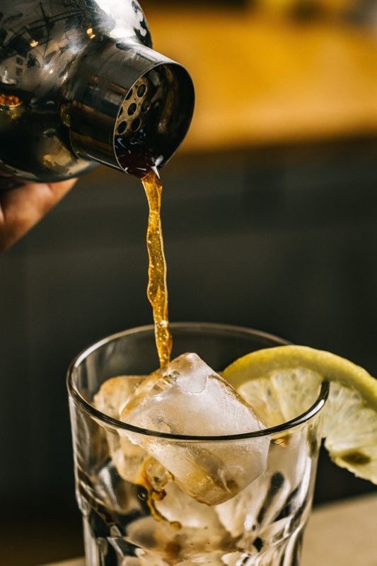 Thé glacé versé du shaker sur glaçons et citron